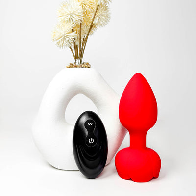 RoseGlow Vibrating Remote Butt Plug on a white background with a decorative vase.