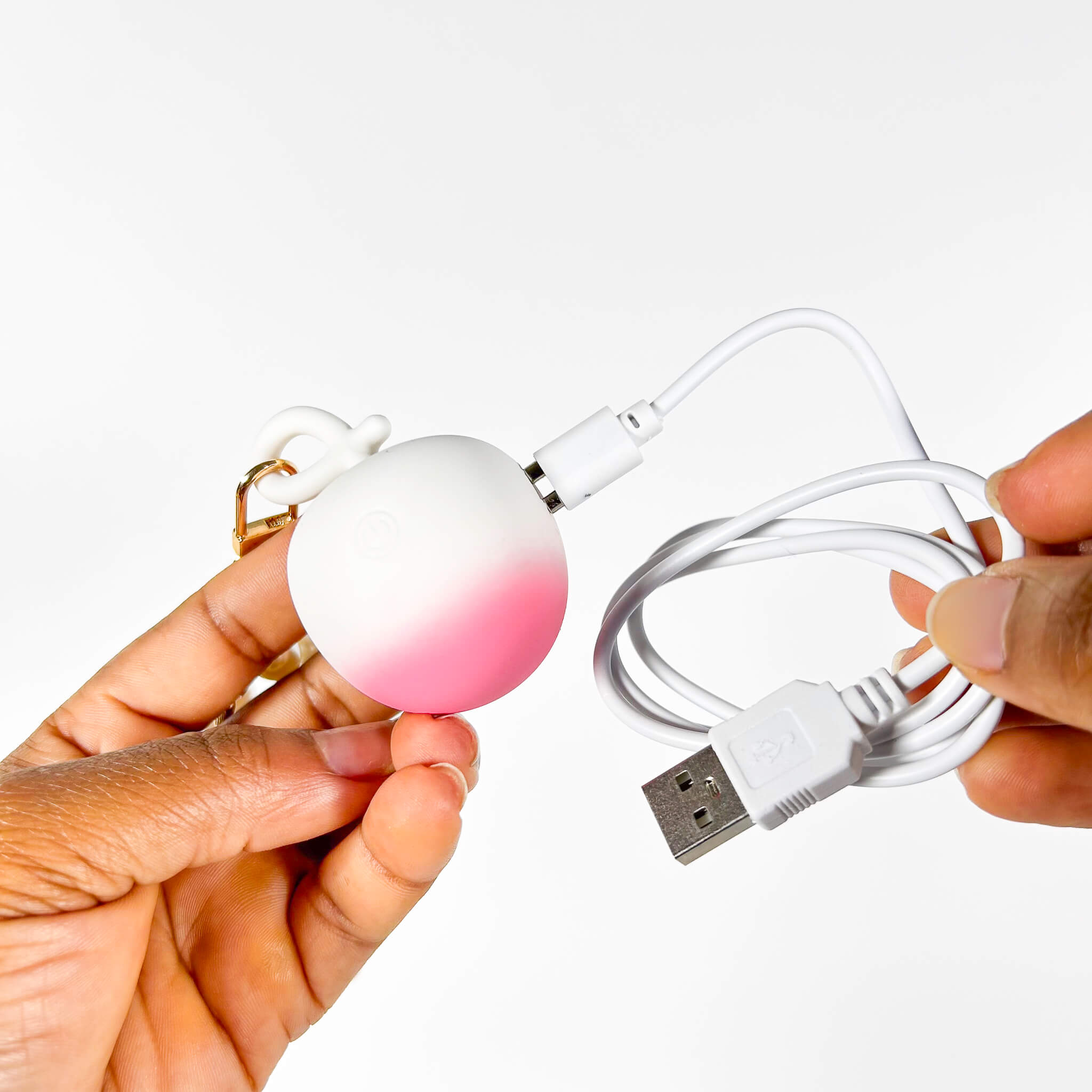 Gradient pink to white Small Discreet Mini Vibrator with USB cable on a white background