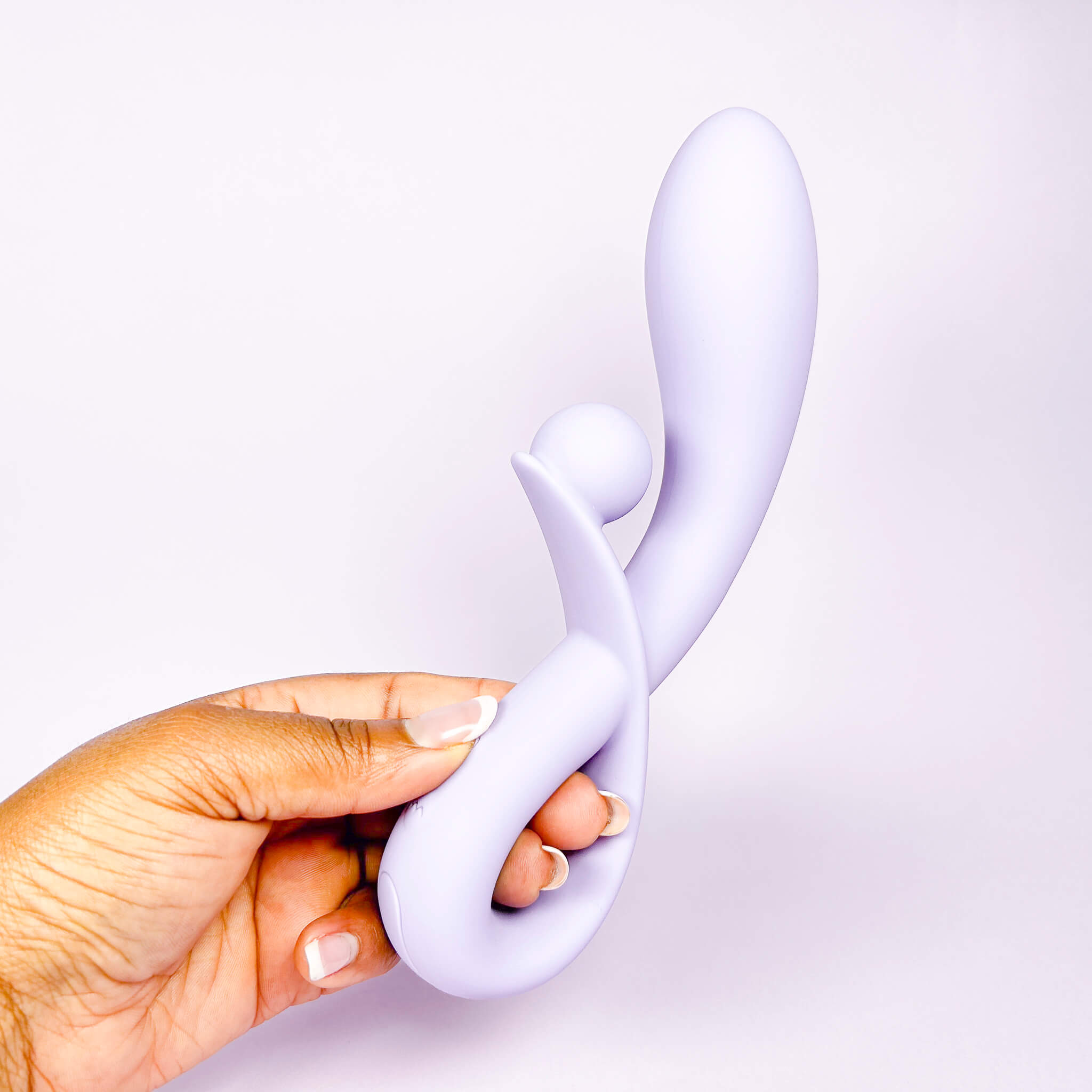 Hand holding a Lilac Sweet Vibe Naughty Rabbit Vibrator against a light purple background