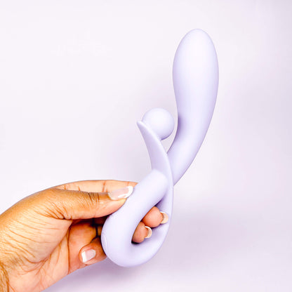 Hand holding a Lilac Sweet Vibe Naughty Rabbit Vibrator against a light purple background
