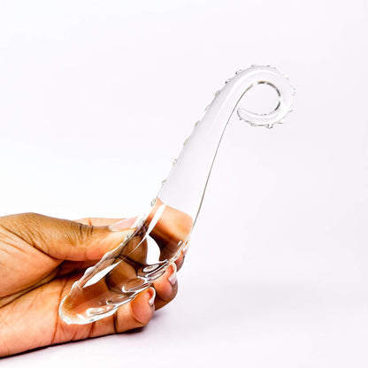 Clearglass dildo held by a hand on a white background