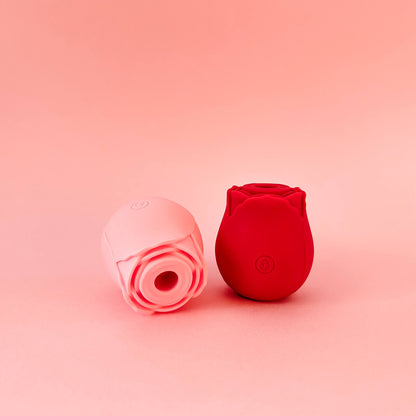 Two silicone rose-shaped products, one pink and one red, on a pink background.
