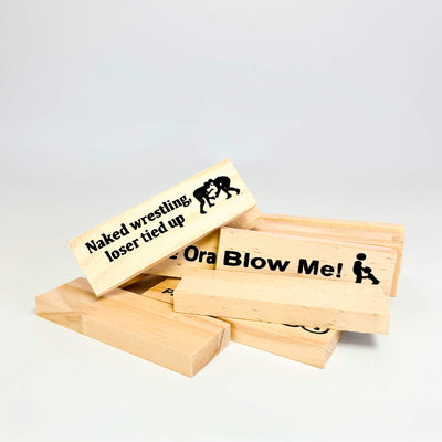 Wooden adult jenga blocks with humorous text and graphics on a light gray background