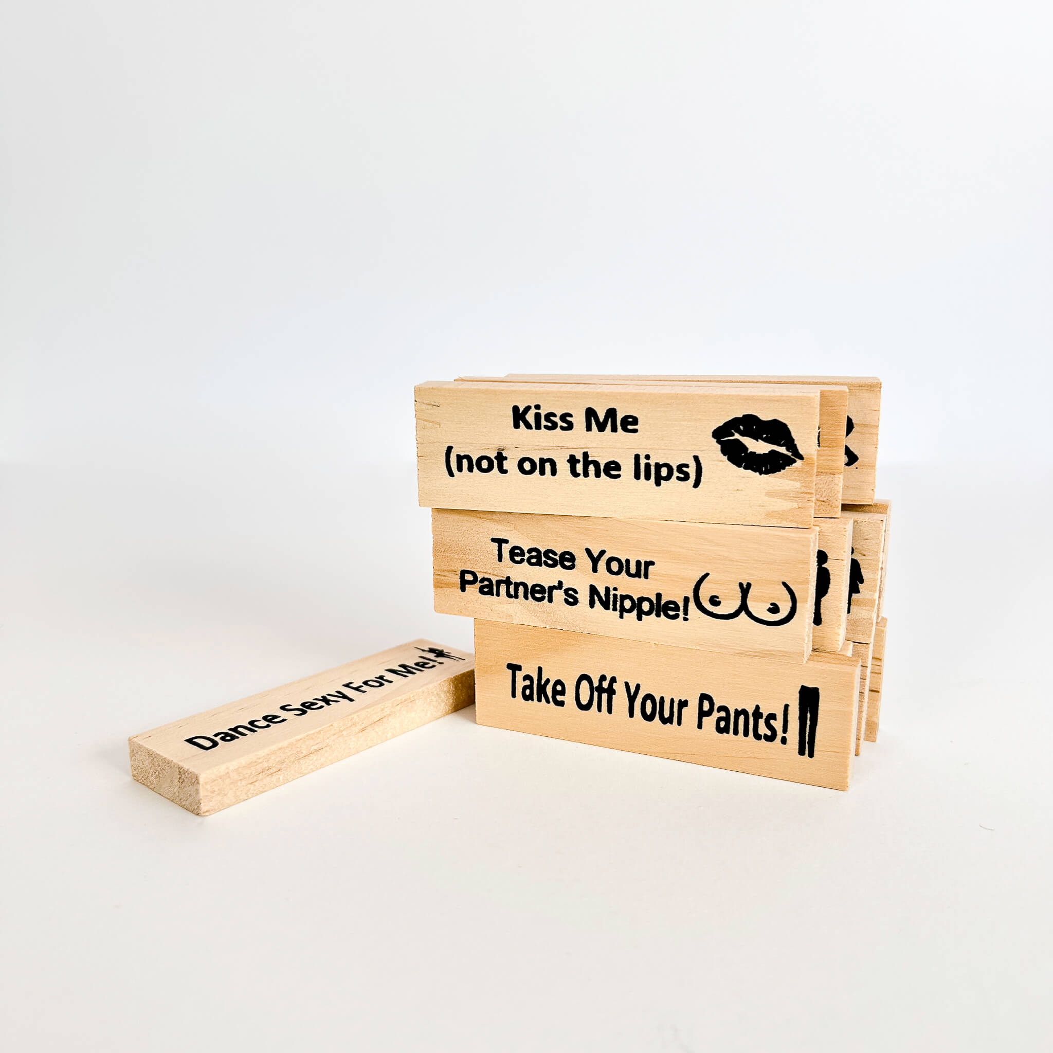 Set of wooden adult jenga blocks with humorous text on a white background
