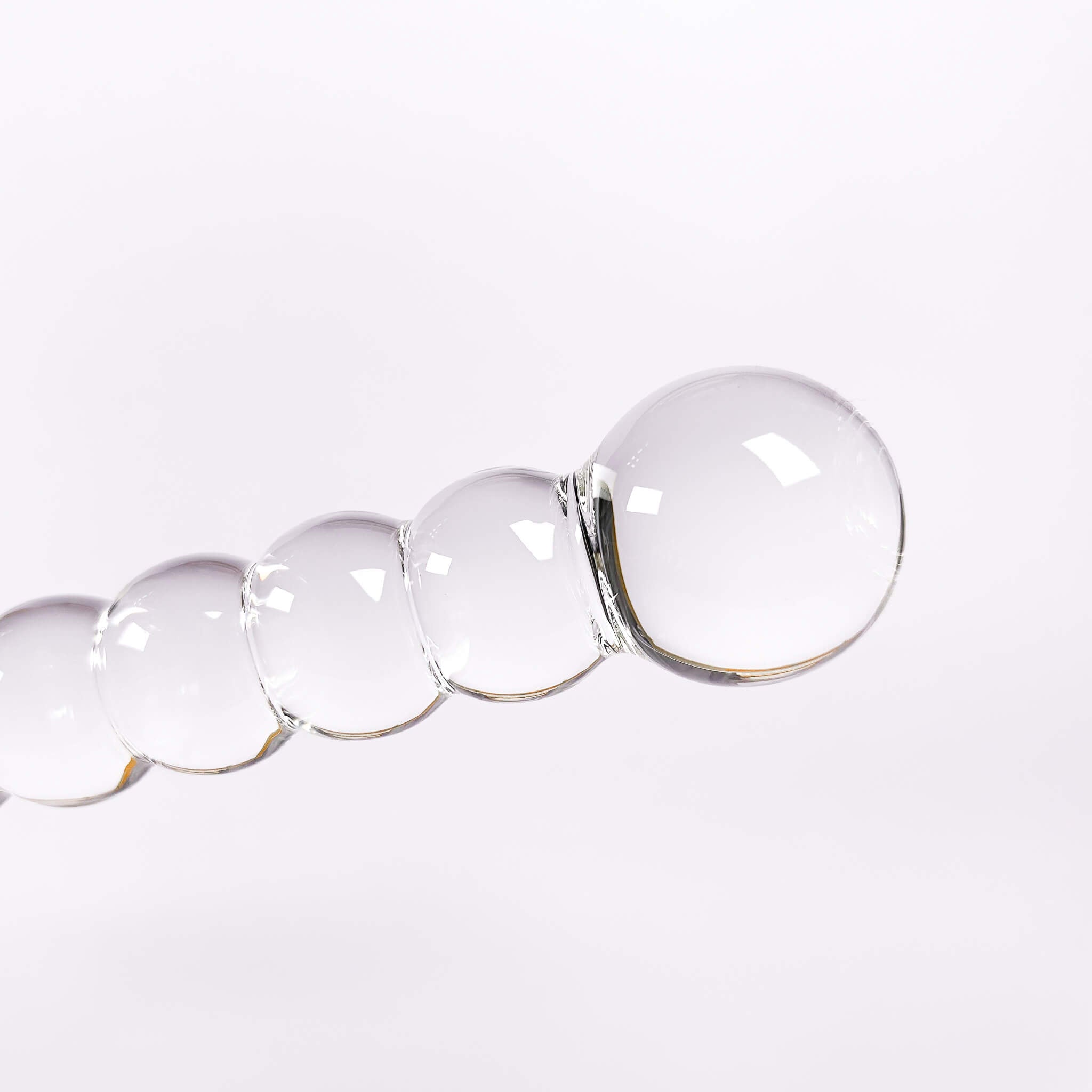 Clear glass beaded dildo on a white background