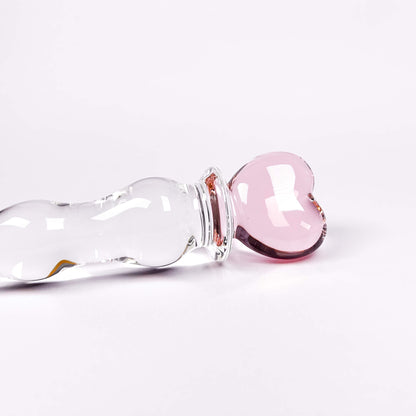 Glass dildo with a pink stopper on a white background