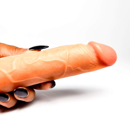 Hand with a realistic anal dildo on a white background
