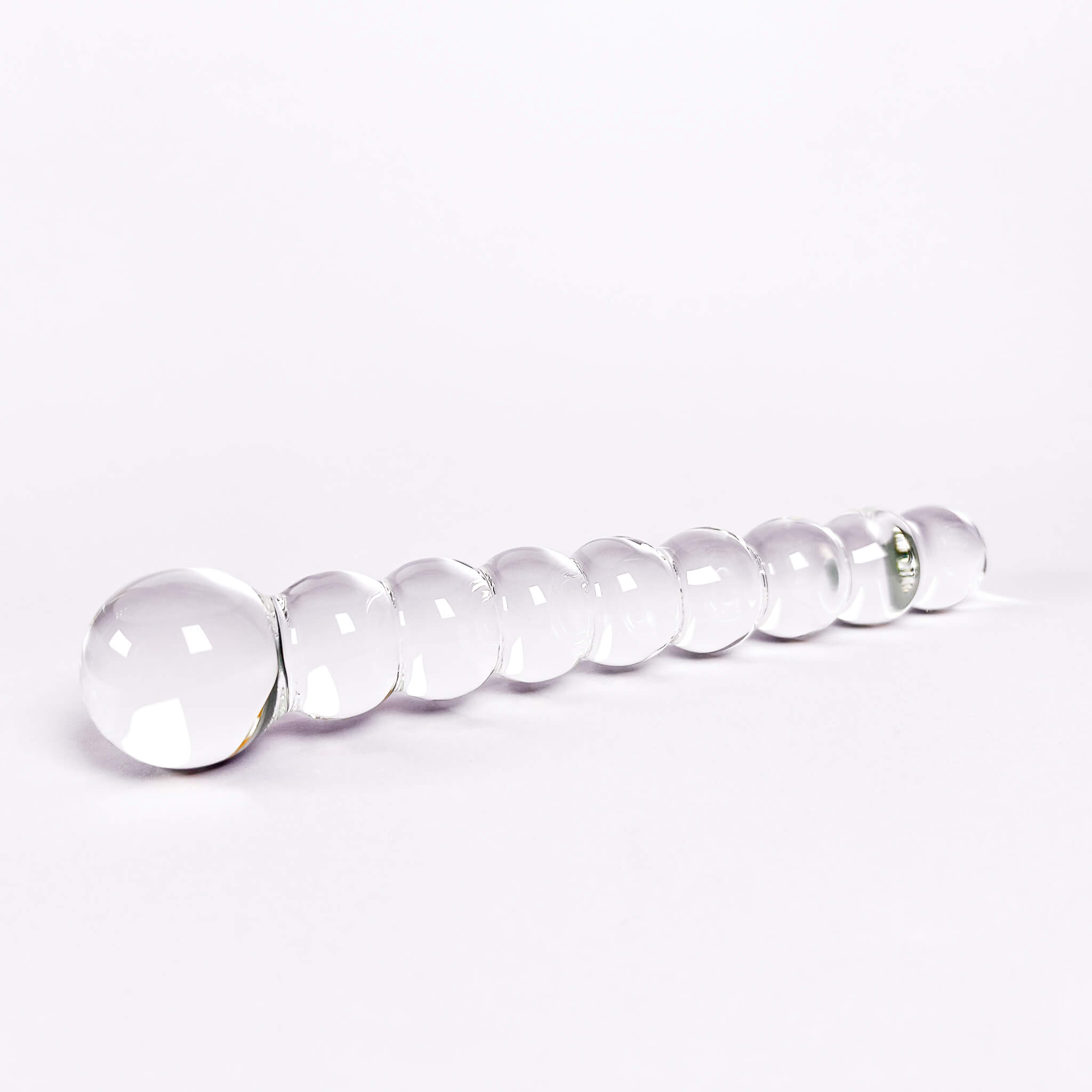 Beaded glass dildo on a white background