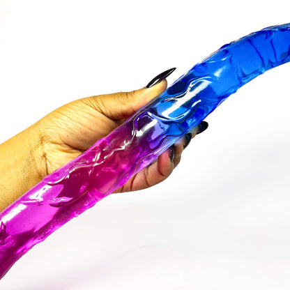 Hand holding a blue and pink buy double dildo against a white background