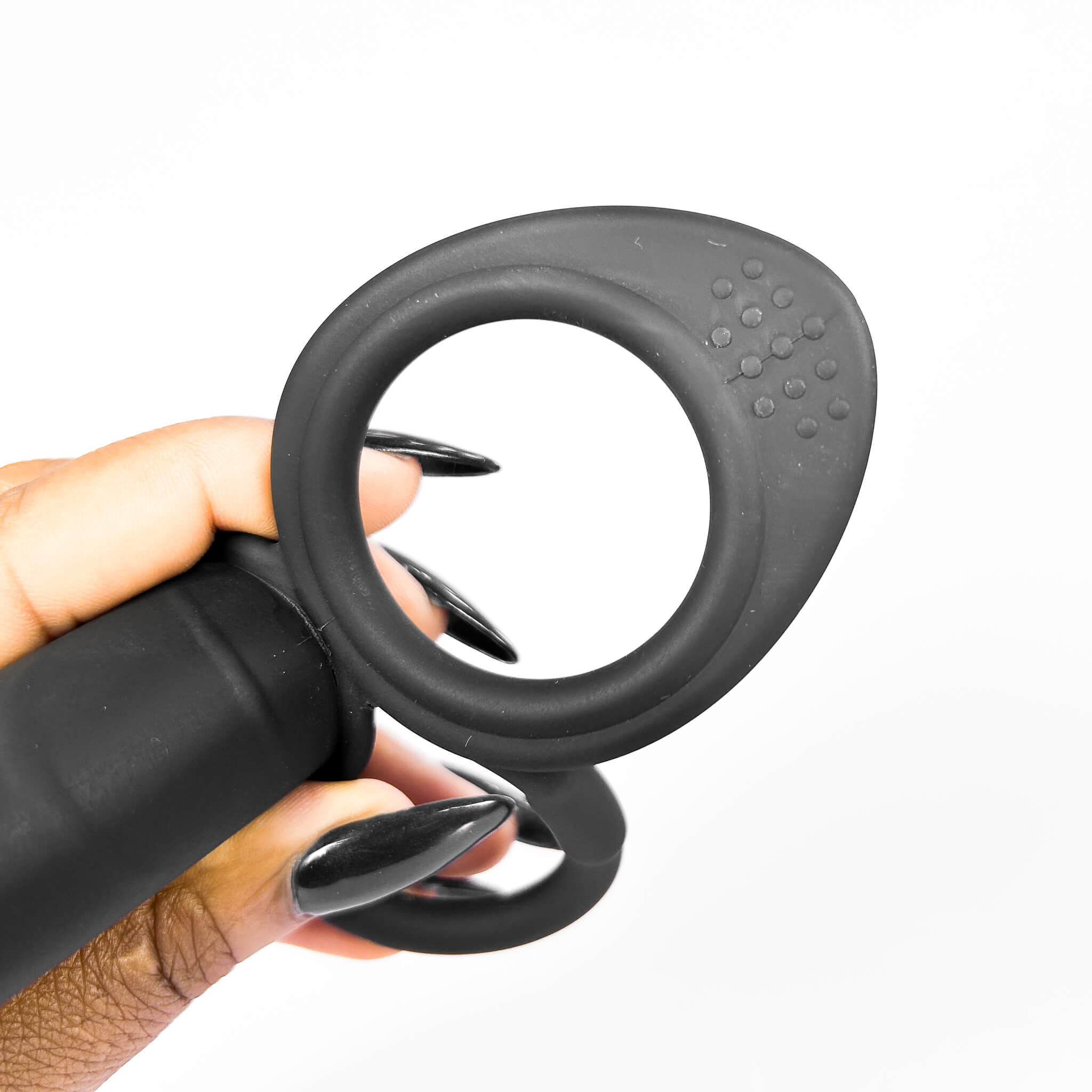 dp cock ring held by a hand on a white background