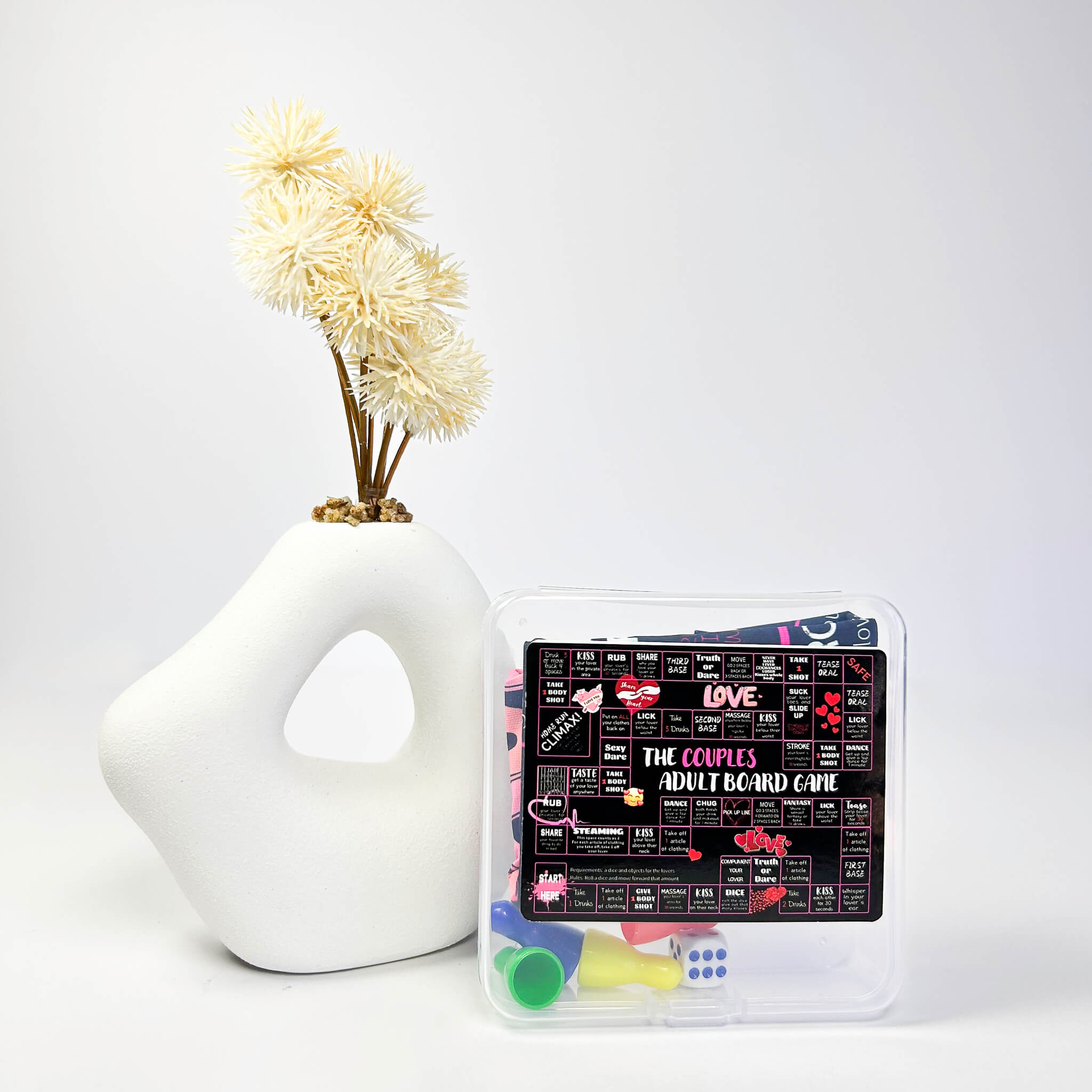 Board game box with 'The Couples Adult Board Game' on a white background with a decorative vase.