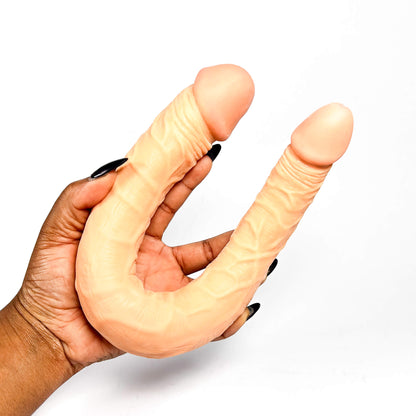 Hand holding a double-sided dildo beginners with a white background