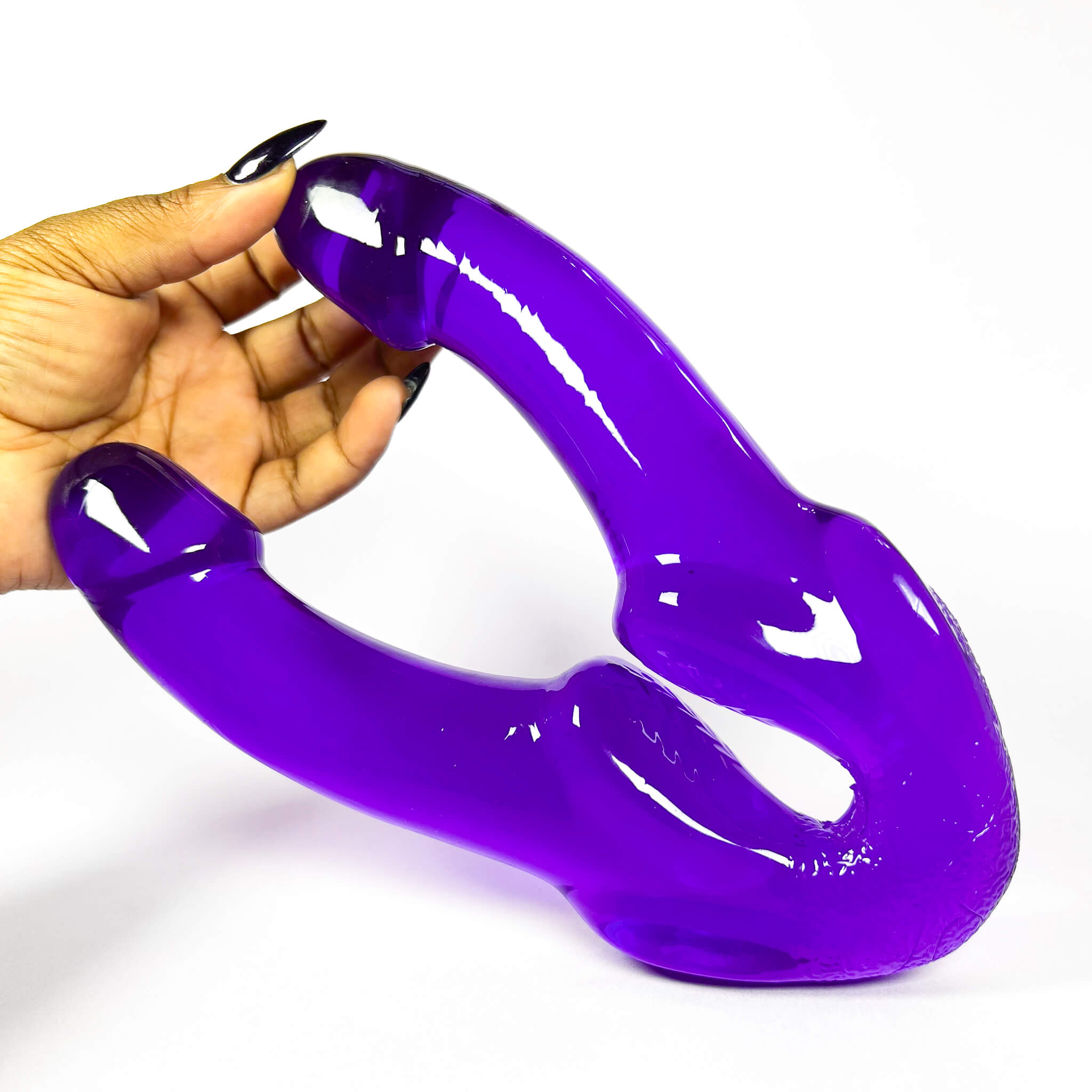Hand holding adouble dildo south africa against a white background