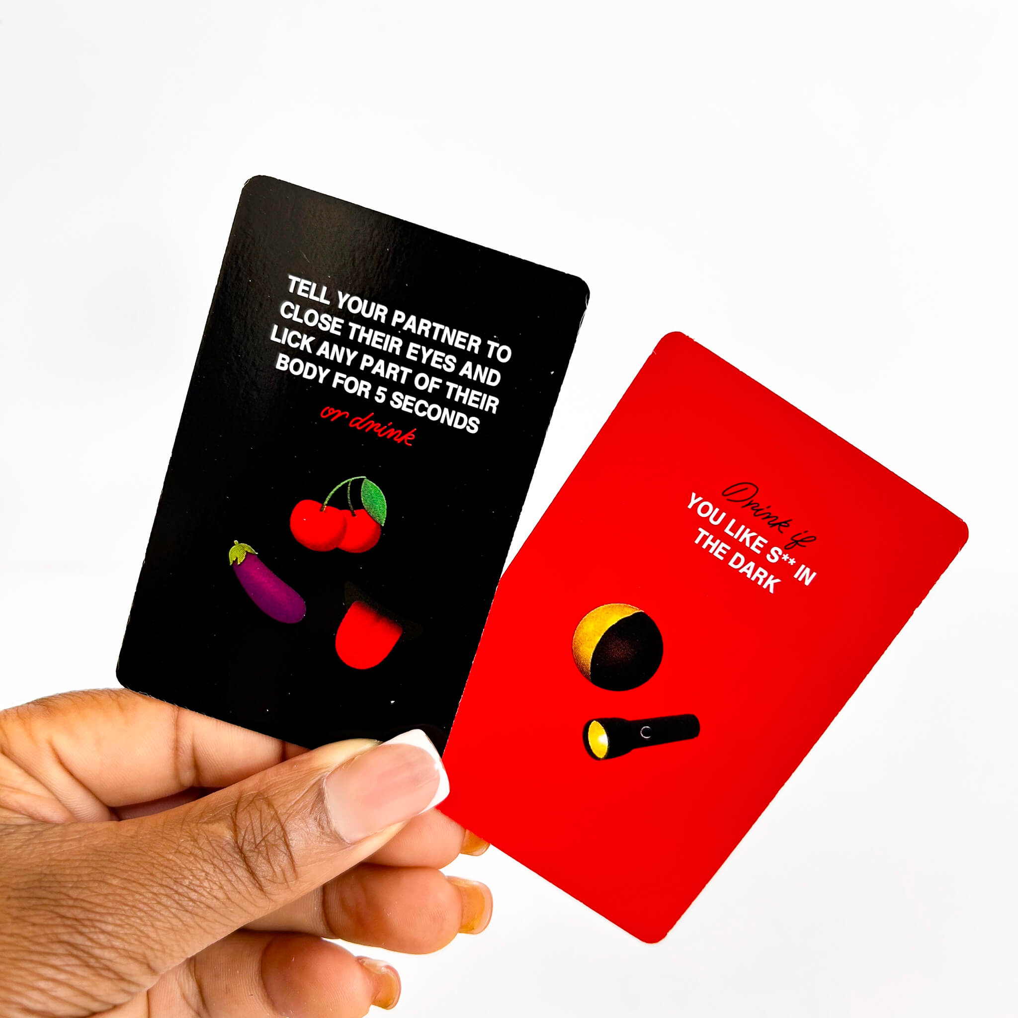 Two cards, one black with text and graphics, the other red with a flashlight graphic, held by a hand.