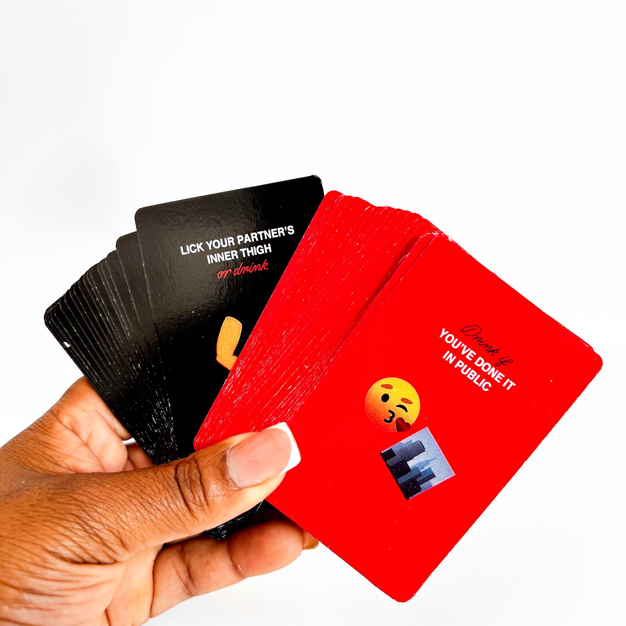 Hand holding a deck of cards with inappropriate text and emojis on a white background