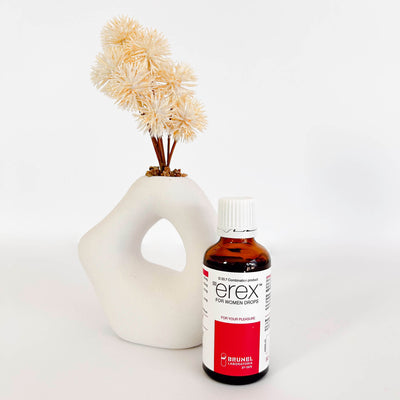 Bottle of erex for women with a decorative vase and flowers on a white background