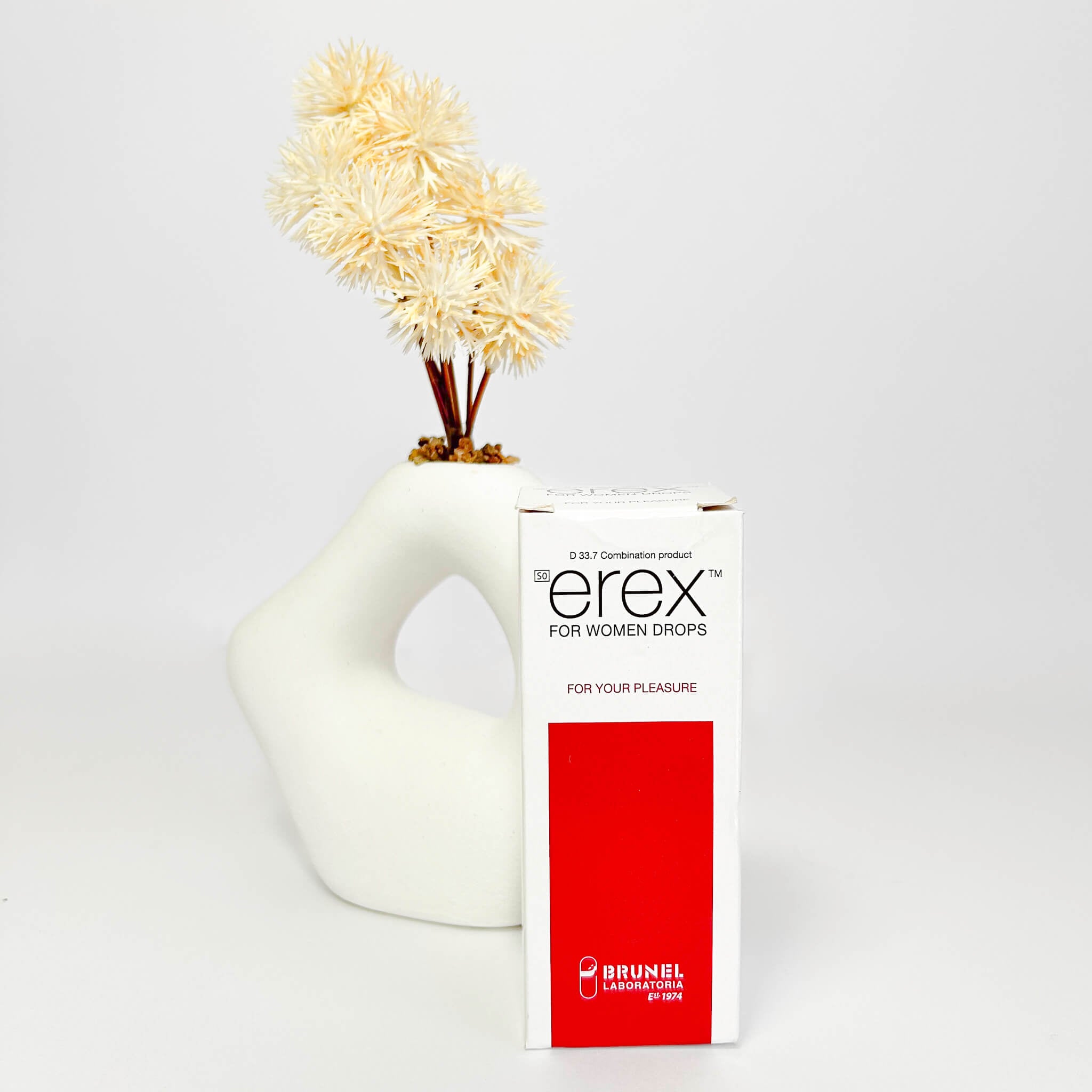 White vase with flowers next to a 'erex' product box on a white background