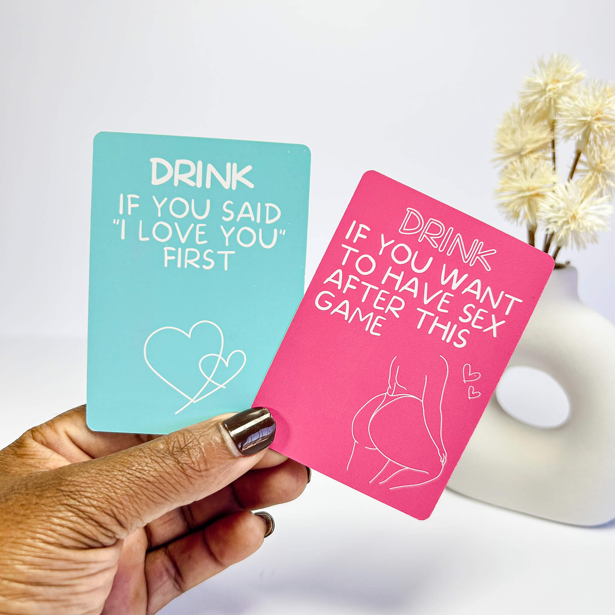 Two excited and exhausted  cards held by a hand, one blue and one pink, with humorous text.