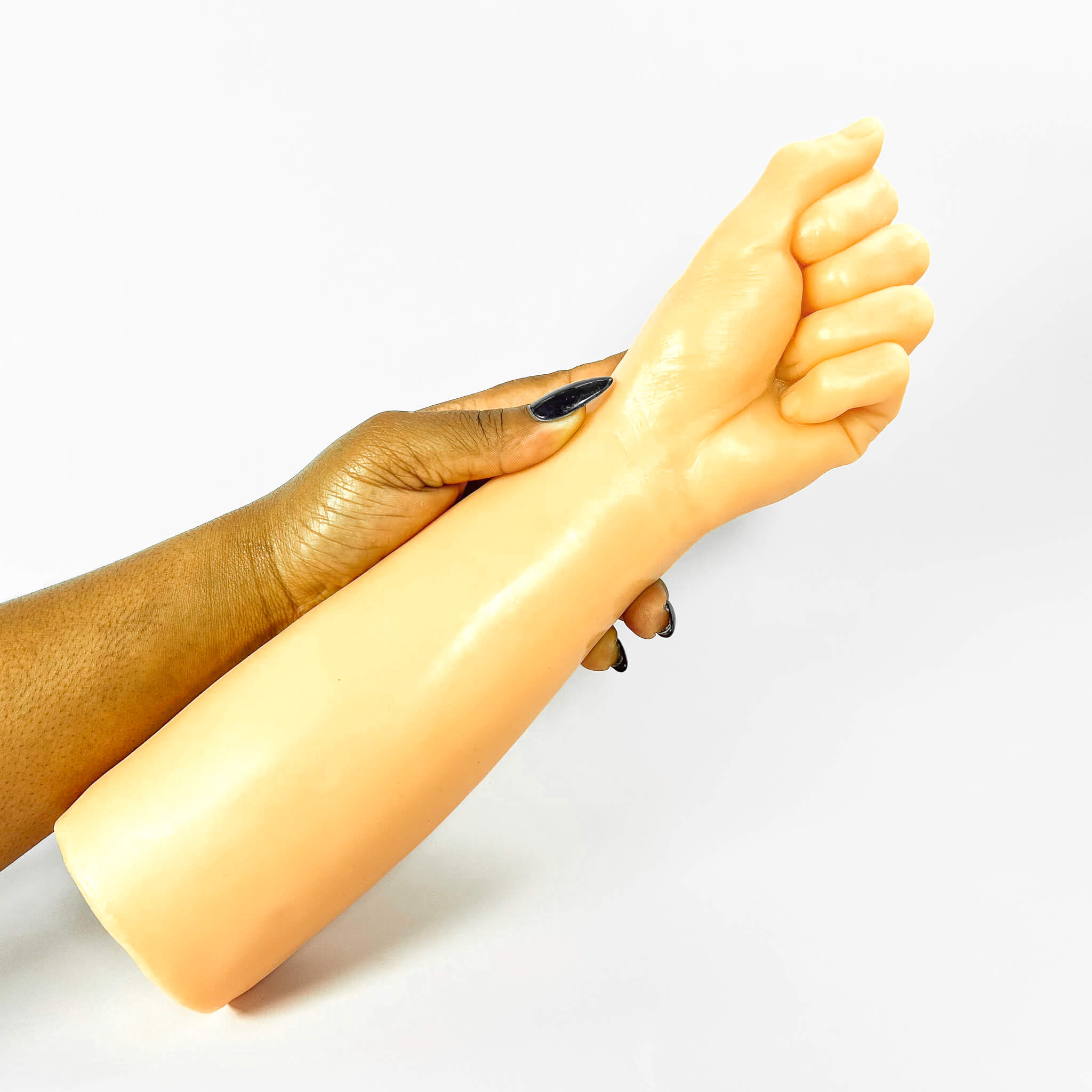 fisting dildo held by a person's arm on a white background