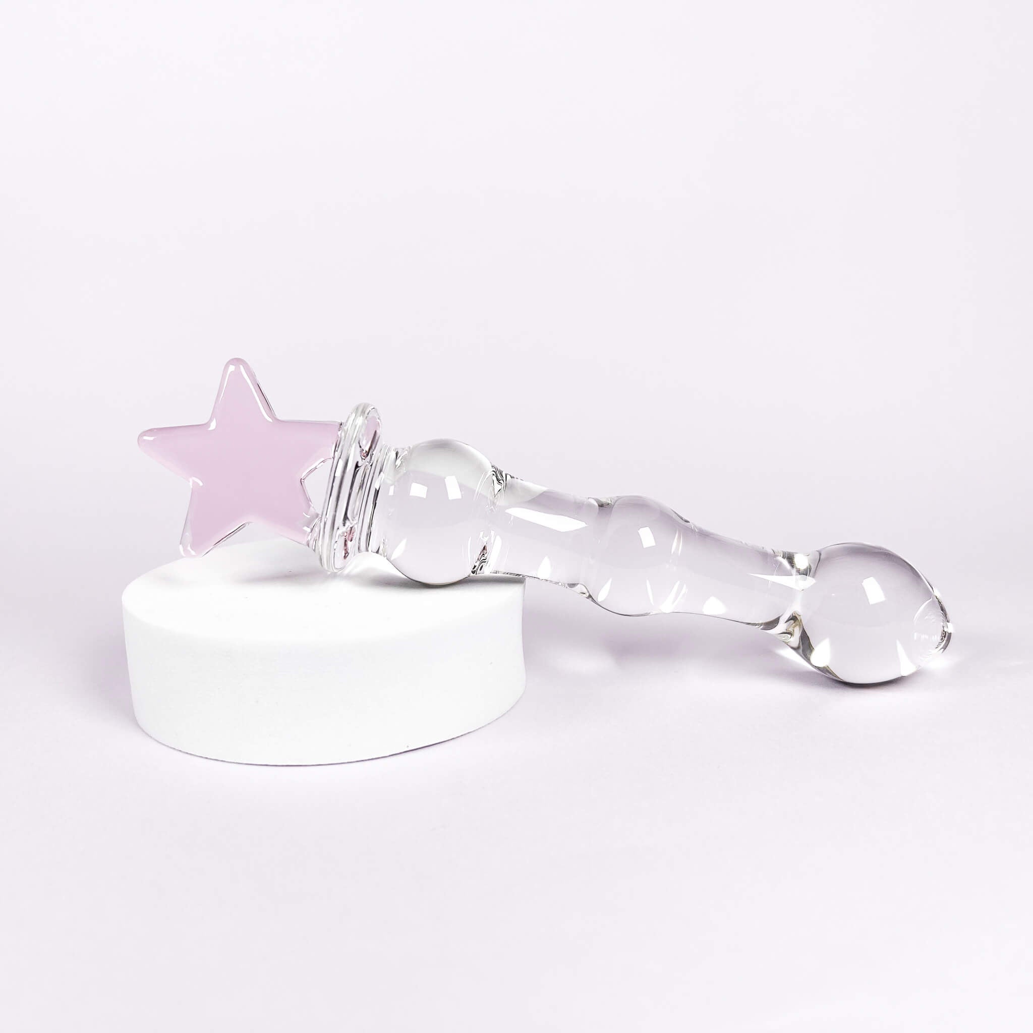 Clear glass dildo with a pink star on a white background