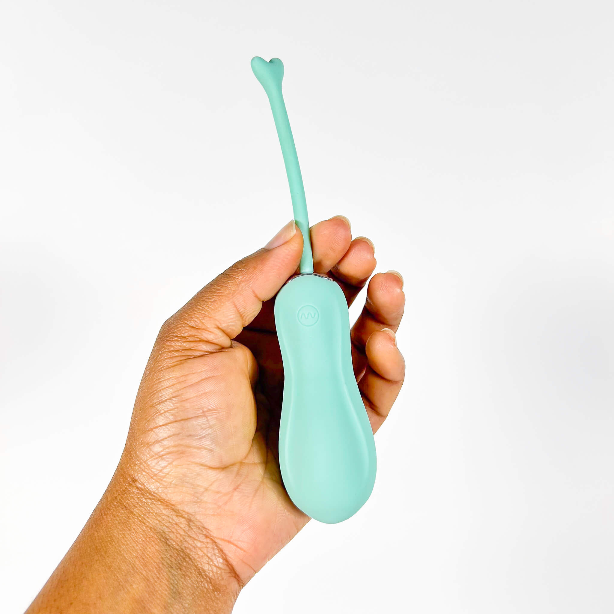 Hand holding a turquoise egg vibrator against a white background