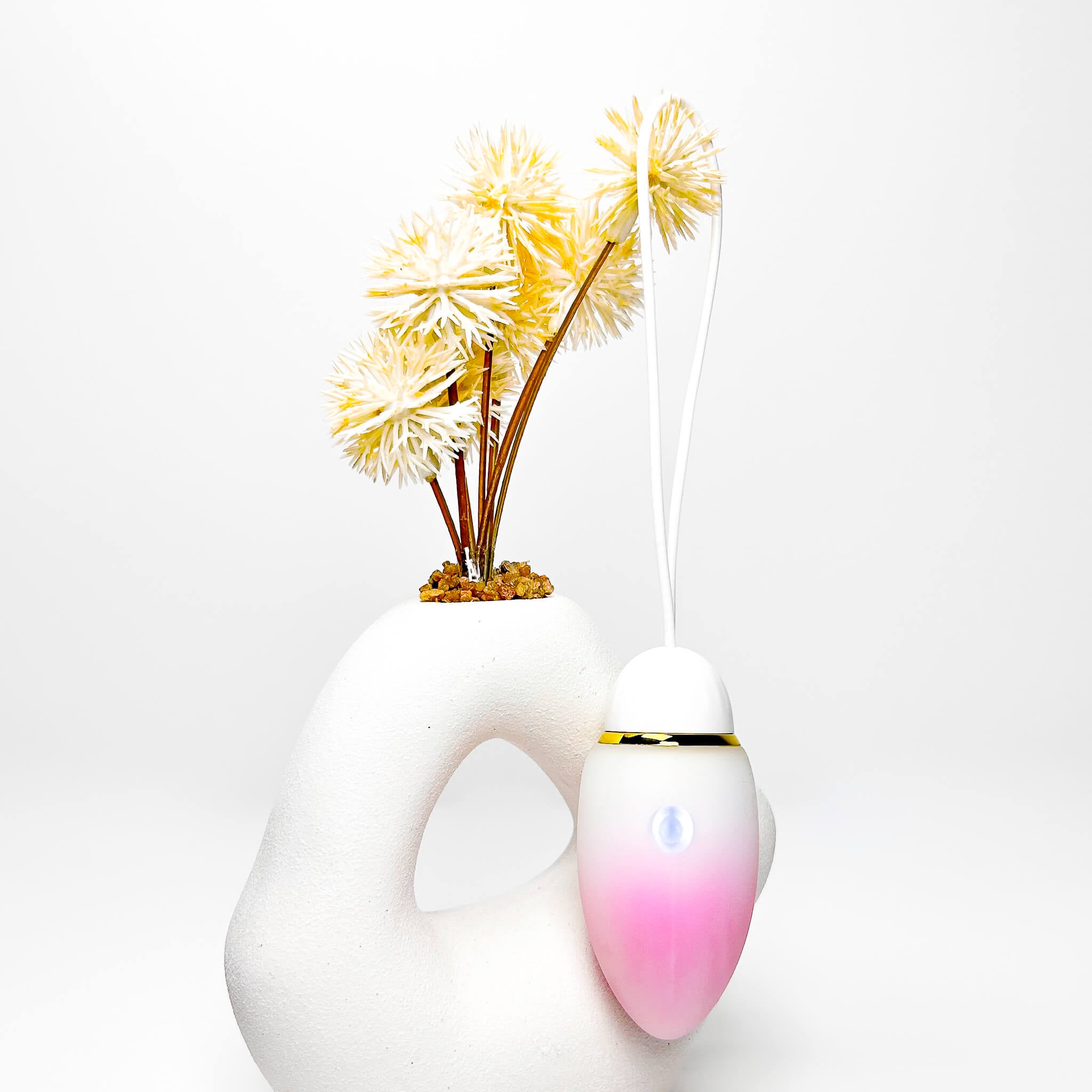 jumping egg sex toy with a gradient pink to white design and yellow flowers on a white background