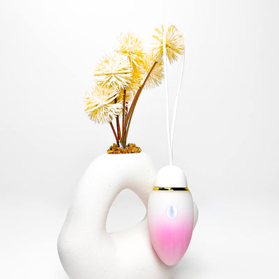 jumping egg sex toy with a gradient pink to white design and yellow flowers on a white background