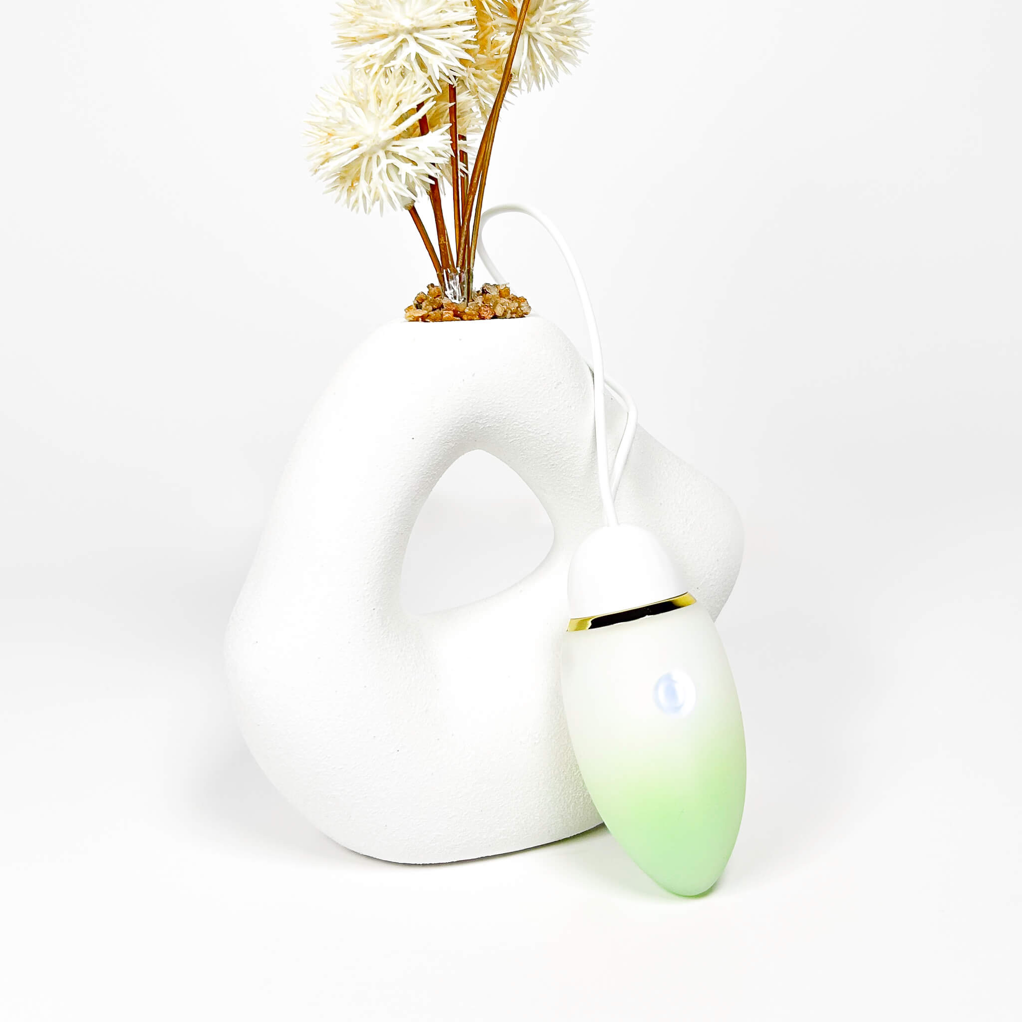 jumping egg sex toy with a green accent on a white background