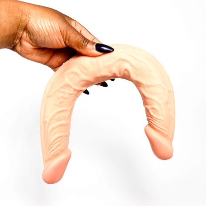 Hand holding a lesbian dildo on a white background