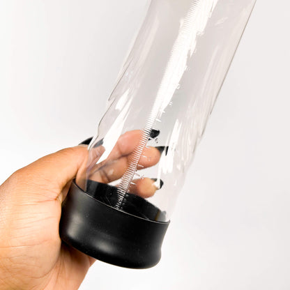 Clear plastic container with black base held by a hand on a white background