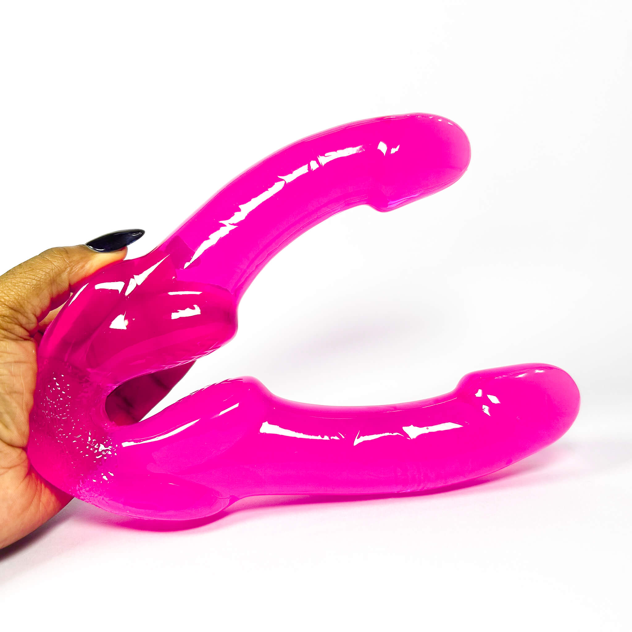 pink double dildo held by a hand on a white background