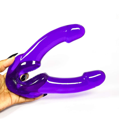 purple double dildo held by a hand on a white background