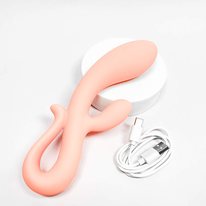 Pink silicone vibrator with white base and USB cable on a light gray background