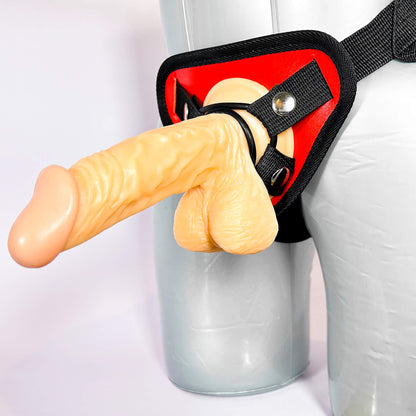 strap on with a realistic design held by a person wearing a white garment.