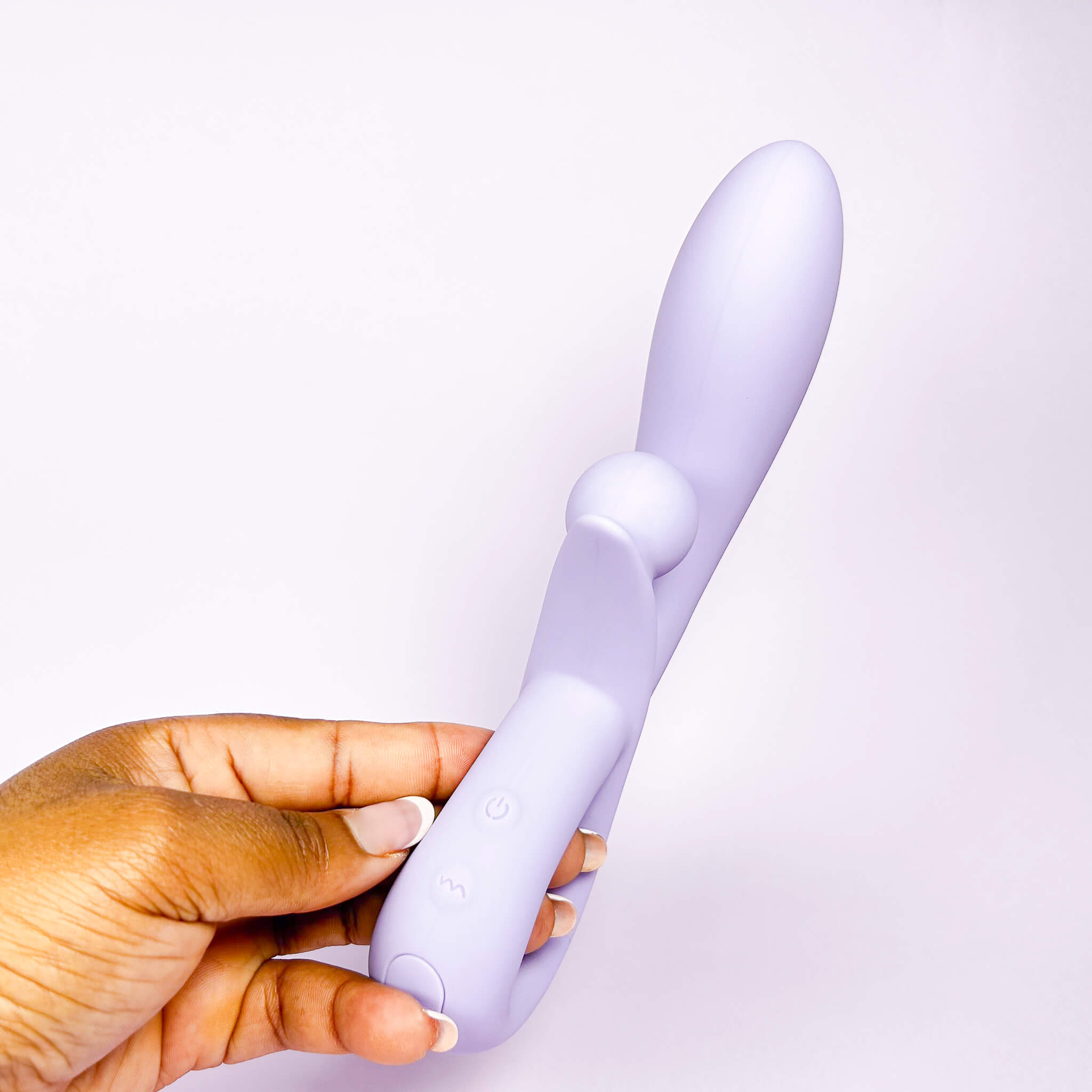 Hand holding a purple rechargeable rabbit vibrator against a white background