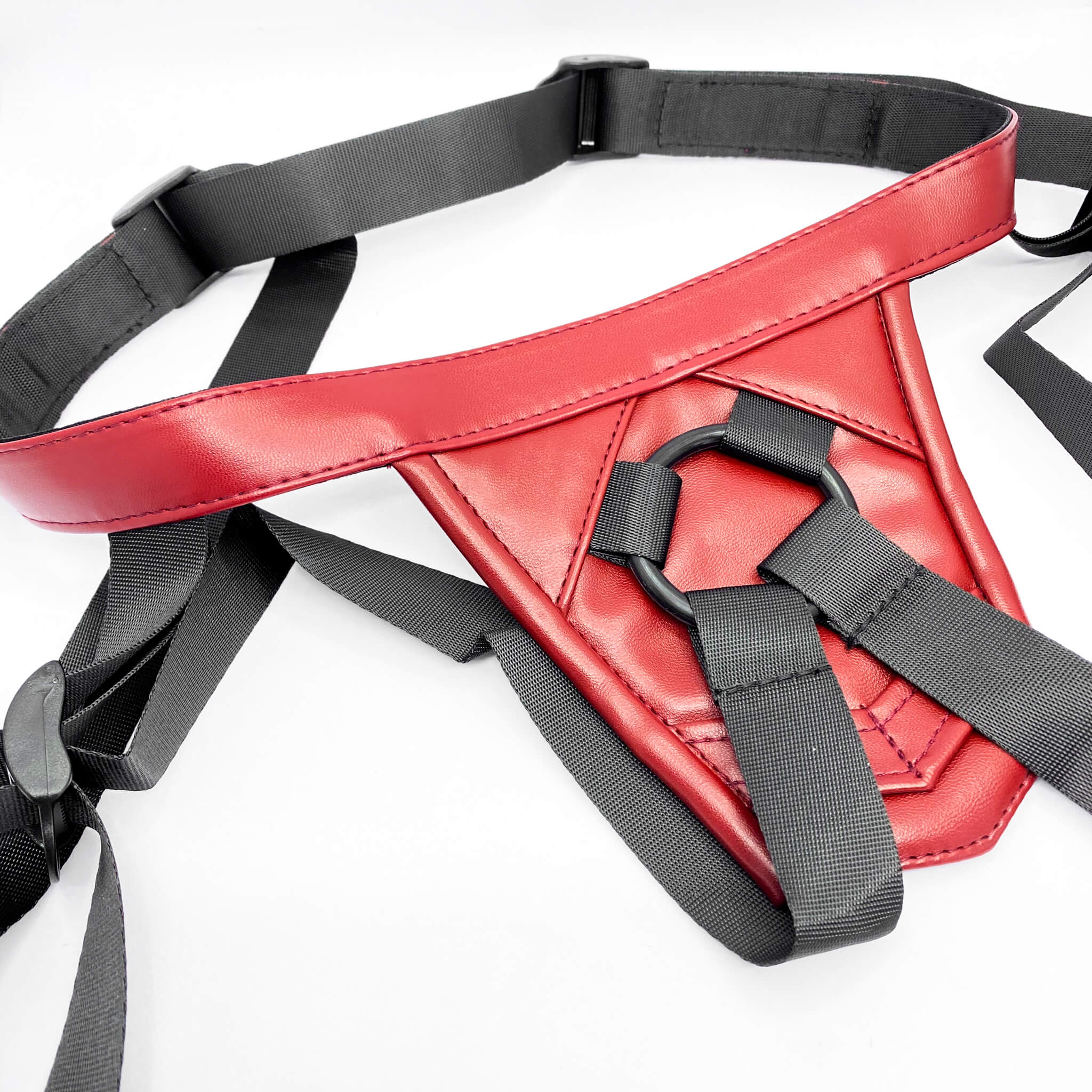 Red leather strap on harness with black straps on a white background